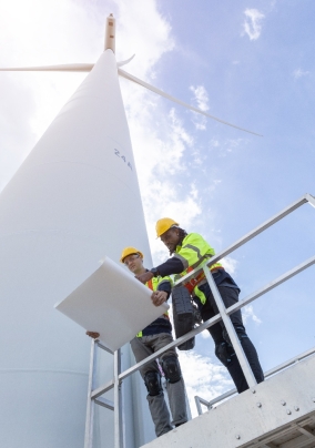 engineers standing on a high platform looking at a blueprint