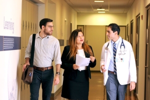 Three people in a hospital hallway talking