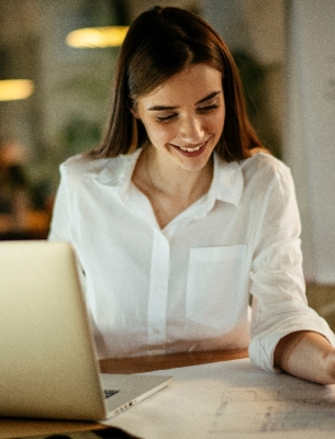 woman taking notes from laptop to notepad