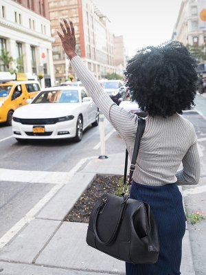 Woman hailing a taxi in New York City