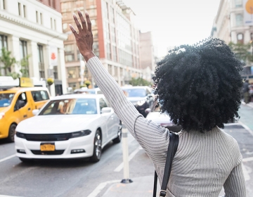 Woman hailing a taxi in New York City