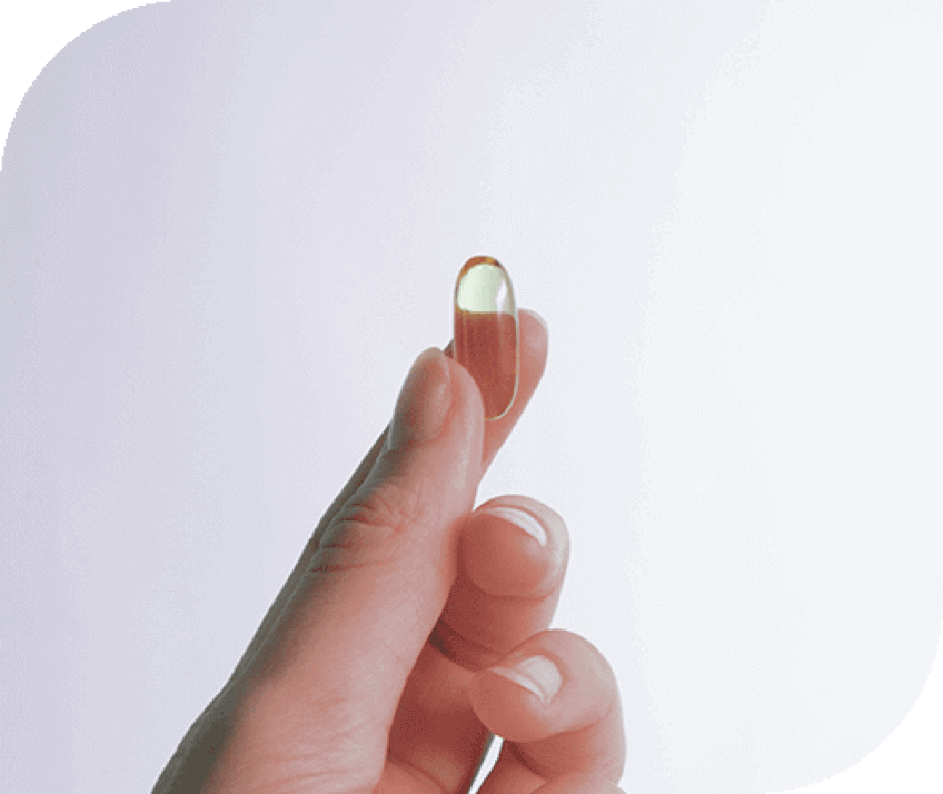 Hand holding an Autumn DNA vitamin capsule between two fingers