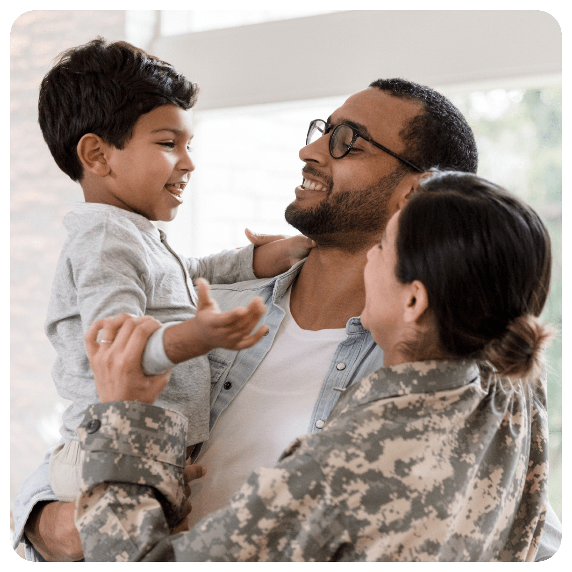 Military parents holding & greeting their young son