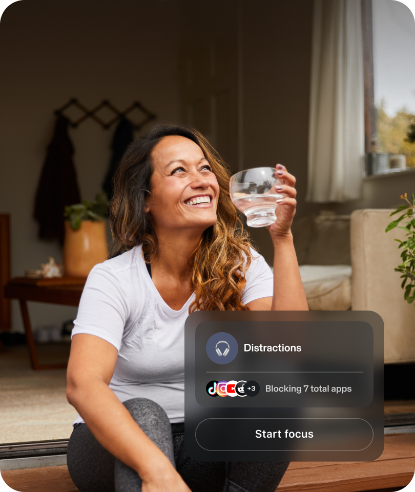 Woman smiling and drinking water. Bubble showing distractions blocking 7 applications.