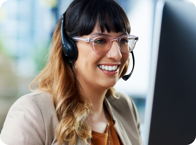 Customer Service Agent talks on her headset while looking at her screen