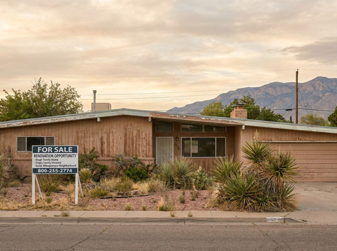 Single-story home with dated exterior and minimal landscaping, ideal for a fixer-upper sale.