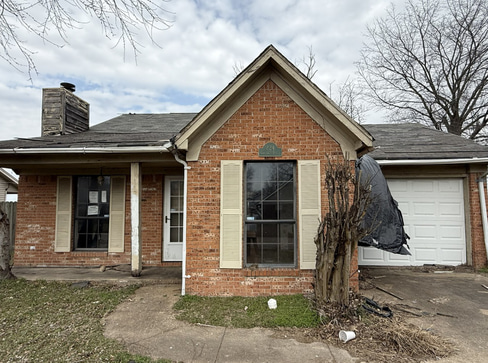 Older home with a detached carport and worn exterior, suitable for renovation or cash sale.