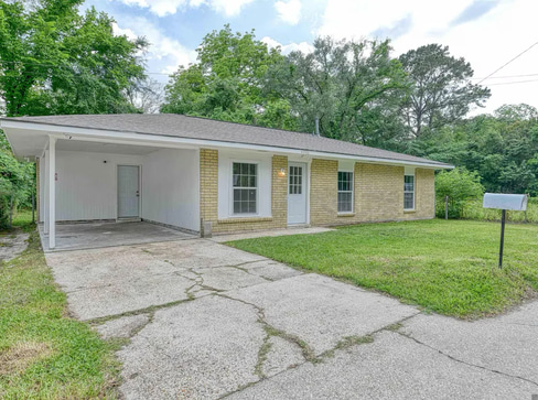 Older single-story home with worn exterior, suitable for renovation or cash purchase.