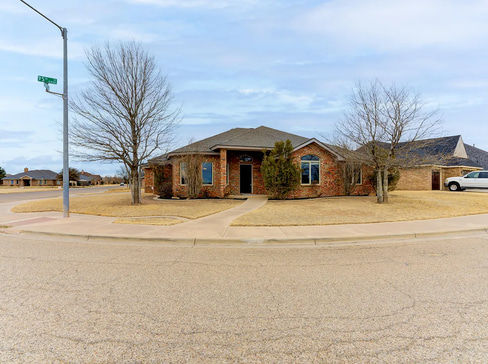 Older home with a detached carport and worn exterior, suitable for renovation or cash sale.