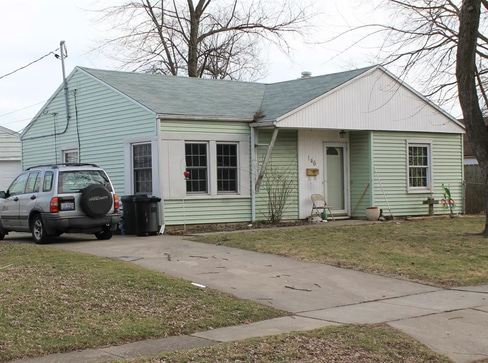 Older home with a detached carport and worn exterior, suitable for renovation or cash sale.