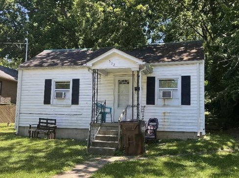 Single-story home with dated exterior and minimal landscaping, ideal for a fixer-upper sale.