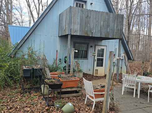 Older home with a detached carport and worn exterior, suitable for renovation or cash sale.