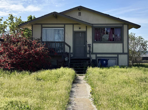 Single-story home with visible exterior wear, ideal for a fixer-upper purchase.