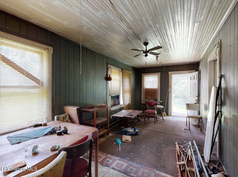Single-story home with dated exterior and minimal landscaping, ideal for a fixer-upper sale.