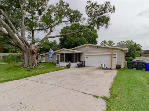 Older home with a detached carport and worn exterior, suitable for renovation or cash sale.