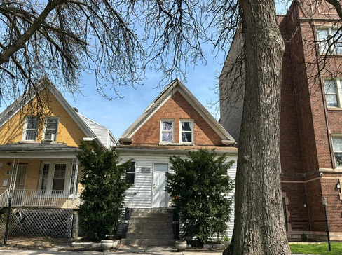 Older home with a detached carport and worn exterior, suitable for renovation or cash sale.