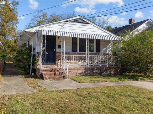 Single-story home with dated exterior and minimal landscaping, ideal for a fixer-upper sale.