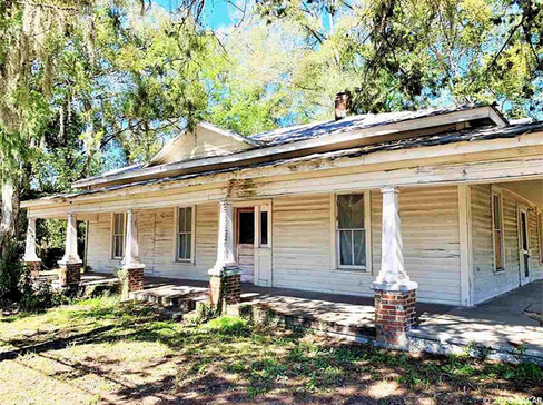 Older single-story home with worn exterior, suitable for renovation or cash purchase.