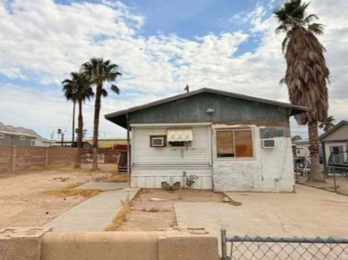 Older single-story home with worn exterior, suitable for renovation or cash purchase.