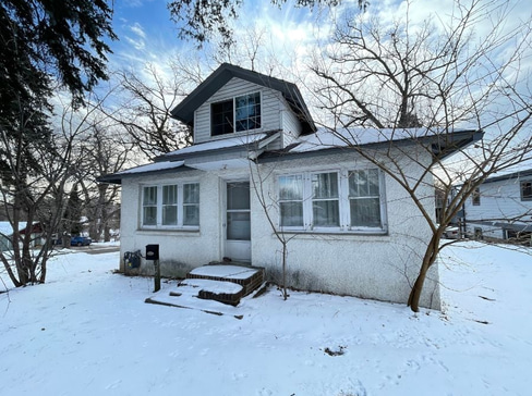 Older single-story home with worn exterior, suitable for renovation or cash purchase.