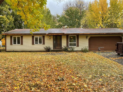 Older home with a detached carport and worn exterior, suitable for renovation or cash sale.