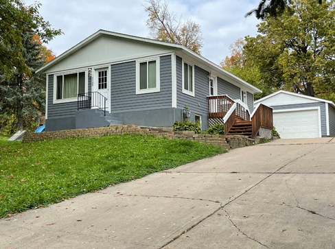 Older home with a detached carport and worn exterior, suitable for renovation or cash sale.