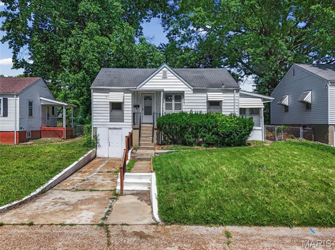 Older home with a detached carport and worn exterior, suitable for renovation or cash sale.