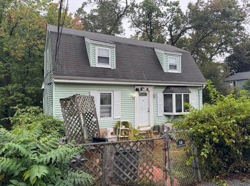 Older single-story home with worn exterior, suitable for renovation or cash purchase.