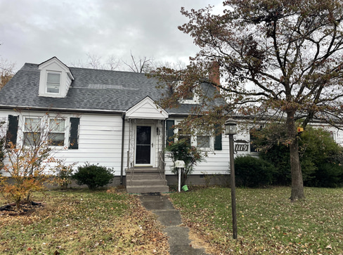 Older home with a detached carport and worn exterior, suitable for renovation or cash sale.