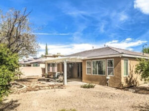Older home with a detached carport and worn exterior, suitable for renovation or cash sale.