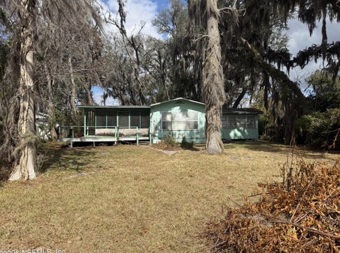 Older single-story home with worn exterior, suitable for renovation or cash purchase.