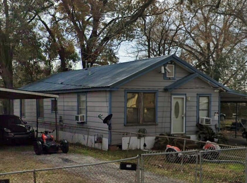 Single-story home with dated exterior and minimal landscaping, ideal for a fixer-upper sale.