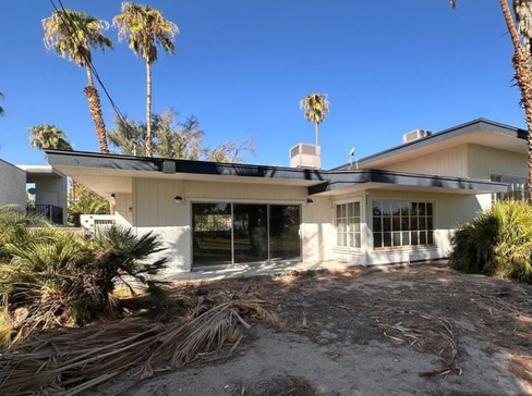Single-story home with dated exterior and minimal landscaping, ideal for a fixer-upper sale.