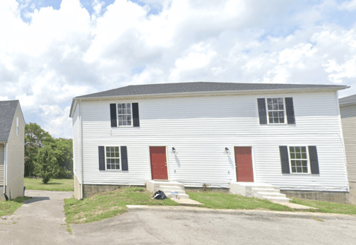Single-story home with dated exterior and minimal landscaping, ideal for a fixer-upper sale.