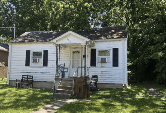 Older single-story home with worn exterior, suitable for renovation or cash purchase.