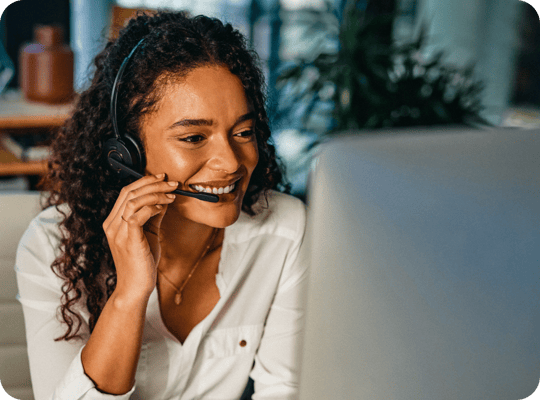A lady on a customer service call with a smile.