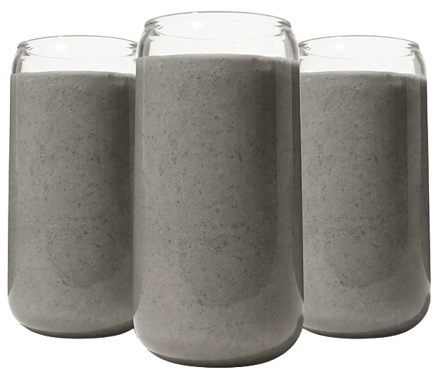 Trei pahare de sticlă tip doză, umplute cu smoothie gri cremos, aranjate simetric pe fundal negru.