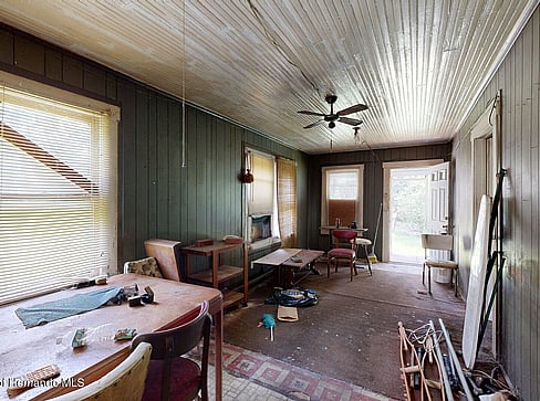 Older home with a detached carport and worn exterior, suitable for renovation or cash sale.