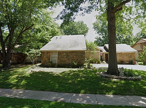 Single-story home with dated exterior and minimal landscaping, ideal for a fixer-upper sale.