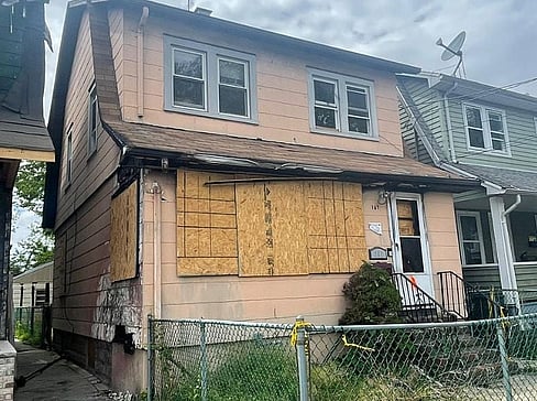 Single-story home with dated exterior and minimal landscaping, ideal for a fixer-upper sale.
