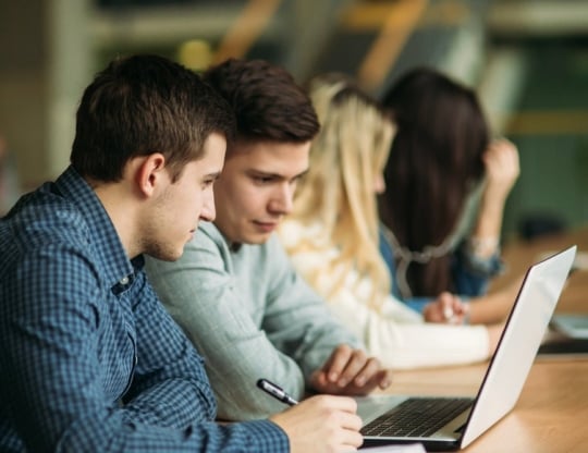 male students studying on one laptop