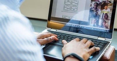 A group of MSBA students sit at tables in a bright room, smiling and engaging in discussion