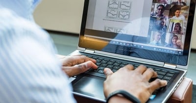 A group of MSBA students sit at tables in a bright room, smiling and engaging in discussion