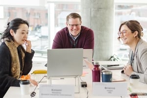 Three executive education students working at a shared table