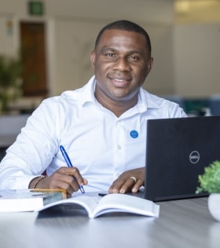 A smiling female CSUSB graduate student smiling while sitting outside.