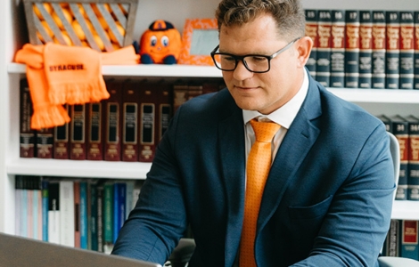 Syracuse student working at his laptop