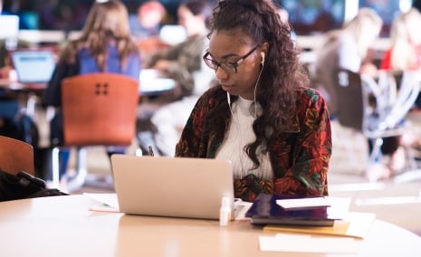 Woman working at laptop in a library
