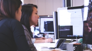 Two women collaborating at a desktop computer