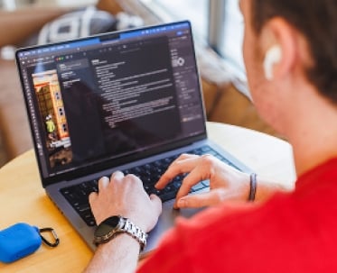 A male student reviewing the Jayhawkville portal on a laptop computer.