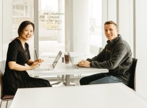 Two Syracuse students working at their laptops